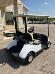 A white golf cart parked in a parking lot.